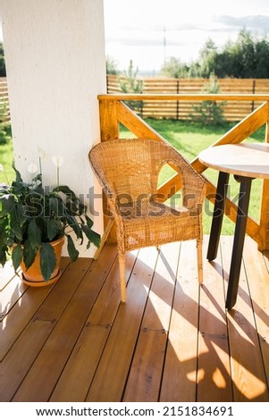 Cozy wooden terrace of country house or cottage with garden view - table and chair for relaxing evening