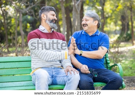 Two happy indian Mature senior men having fun at park outdoor, Asian friends enjoy life, retirement and life insurance concept. Royalty-Free Stock Photo #2151835699