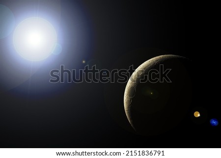 Young Moon illuminated by the rays of the sun, with lens flare effect (photomontage).