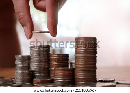People hand putting coins increase arranged on white background table with blank copy space. to convey the concepts of finance and business