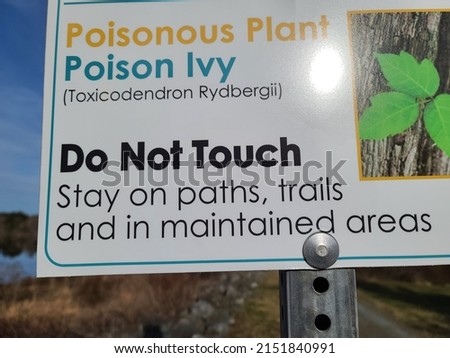 The close up image of a sign warning of poison ivy. There is a picture to help identify it, its scientific name, and a warning that says "Do Not Touch. Stay on paths, trails, and in maintained areas."
