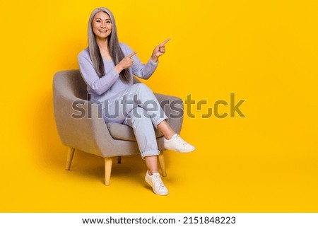 Full length photo of cheerful good mood grandma promoting furniture shop isolated on yellow color background
