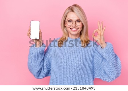 Photo of funny mature blond lady show okey telephone wear eyewear blue sweater isolated on pink color background