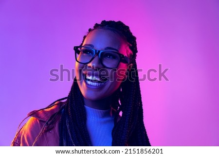 Smiling. Portrait of female fashion model in cotton shirt isolated on purple background in neon light. Concept of beauty, art, fashion, youth, sales and ads. Pretty woman laughing Royalty-Free Stock Photo #2151856201