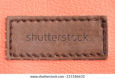 Brown leather blank label on brown jeans background