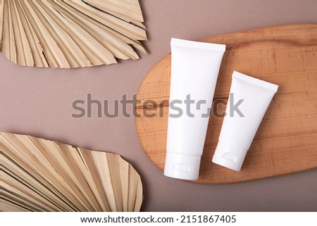 Top view of two blank cosmetics tubes on wooden podium.Earth tones,eco friendly concept.