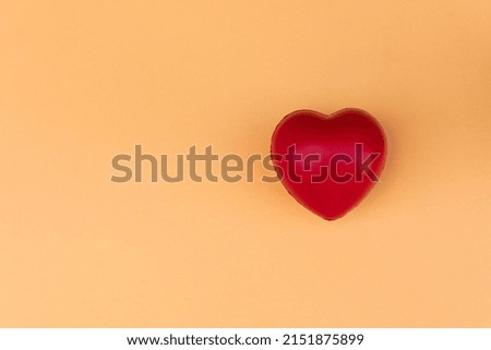 Red heart shape on peach background.Top view. Copy space.MOCKUP Concept of love and health.