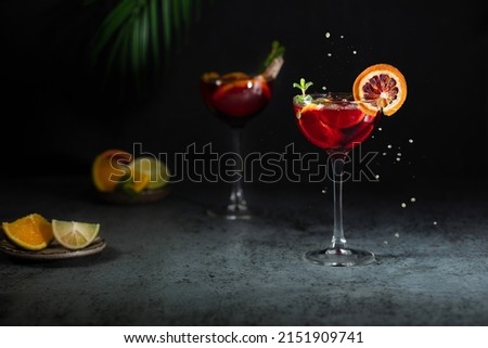 Sangria and ingredients. Refreshing sangria or punch with fruit in glasses . Sangria of red wine with ice. Traditional Spanish sangria . Drops from a squeezed orange. Royalty-Free Stock Photo #2151909741