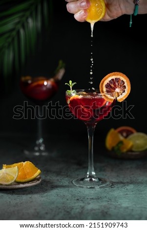 Sangria and ingredients. Refreshing sangria or punch with fruit in glasses . Sangria of red wine with ice. Traditional Spanish sangria . Drops from a squeezed orange. Royalty-Free Stock Photo #2151909743