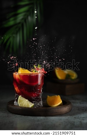 Sangria and ingredients. Refreshing sangria or punch with fruit in glasses . Sangria of red wine with ice. Traditional Spanish sangria . Drops from a squeezed orange. Royalty-Free Stock Photo #2151909751