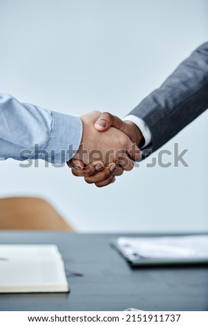 Vertical close up of two business people shaking hands at meeting against simple blue background Royalty-Free Stock Photo #2151911737