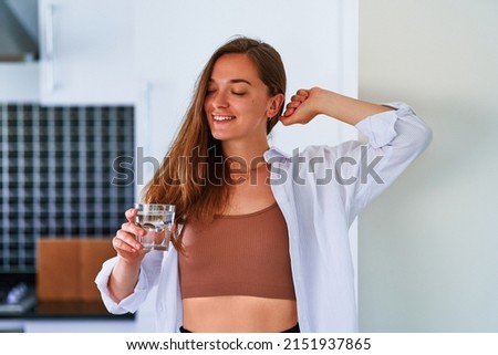 Portrait of happy young satisfied cute attractive woman drinking glass of fresh filtered pure water in morning after waking up. Start day with Healthy habits and support daily water balance Royalty-Free Stock Photo #2151937865