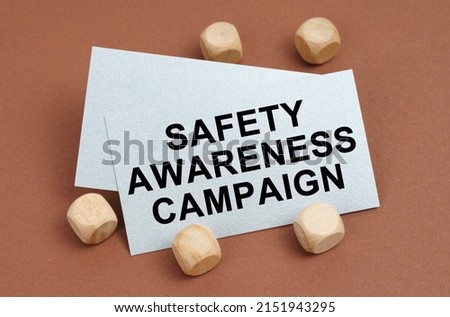The concept of industrial safety. On a brown surface, wooden cubes and a business card with the inscription - Safety Awareness Campaign