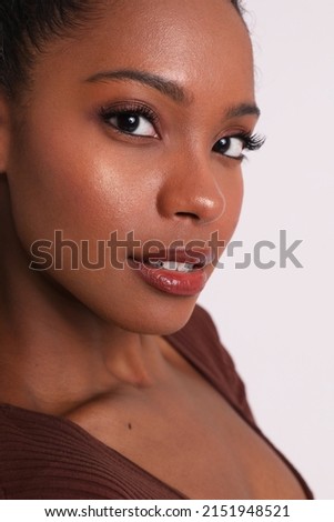 Vertical portrait of dark skinned young woman poses indoor. Body and skin care. 