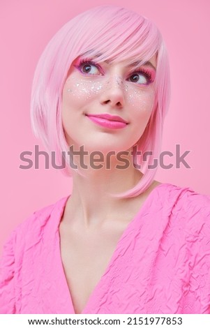 Girly pink style. Portrait of a pretty teenage girl with pink hair, pink makeup and cute shiny freckles. Asian anime style. Pink background.