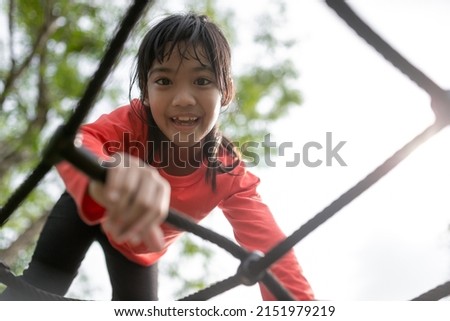 Asian little girl enjoys playing in a children playground, Outdoor portrait