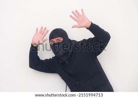 Thief wearing balaclava gets caught red handed, asking for forgiveness Royalty-Free Stock Photo #2151994713