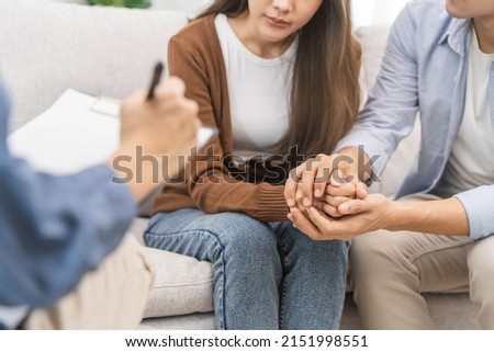 Psychology, depression asian young couple, patient consulting problem mental health with psychologist, psychiatrist at clinic together, husband encouraging by holding hand of wife, therapy health care Royalty-Free Stock Photo #2151998551