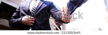 Business shaking hands,project finishing up meeting. Successful businessmen handshaking after good deal.Manager in formal suit in under construction site.banner cover design.