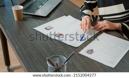 Office worker analyzing candidates cv and application form before attending job interview and hiring people. Recruiter searching on papers for person with business expertise. Close up. Royalty-Free Stock Photo #2152004277