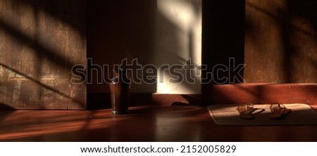 Early morning sunlight casting shadows on the wall inside a room creating a pleasing brown picture