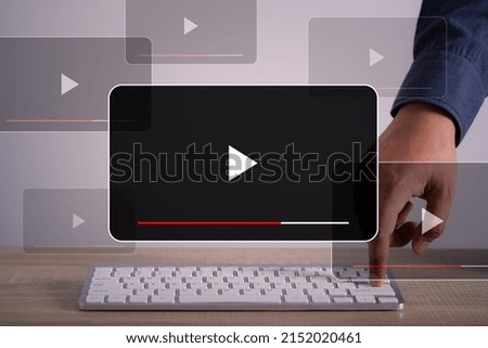 Person using computer laptop watching Video streaming on internet, content online movie or TV ,live concert, show or tutorial on the virtual screen with play button.