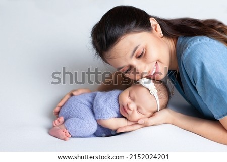 Beautiful young mother with a newborn daughter in a diaper on a white background. Motherhood. Tenderness. Space for text. High quality photo Royalty-Free Stock Photo #2152024201