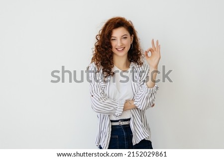 Impressed smiling girl with red hair, shows okay OK sign and look amazed, praise cool promo offer, make compliment, show zero gesture, white background