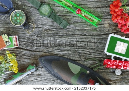 A set of items for survival in nature and in case of danger. On wood texture.