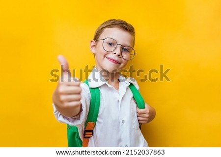 Young school boy showing ok isolated on yellow background. Positive kid looking to camera with confident. Stylish child go back to school