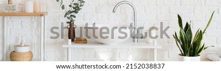 Beautiful interior of modern bathroom with sink near white brick wall