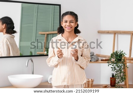 African-American teenage girl with tooth brush and paste in bathroom