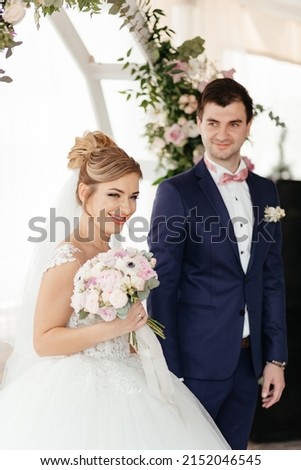 Bride and groom together near decorative arch. High quality photo