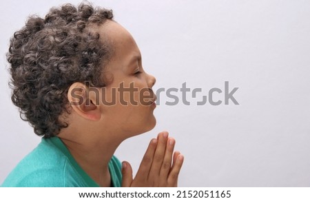 boy praying to God with hands together with people stock photo 