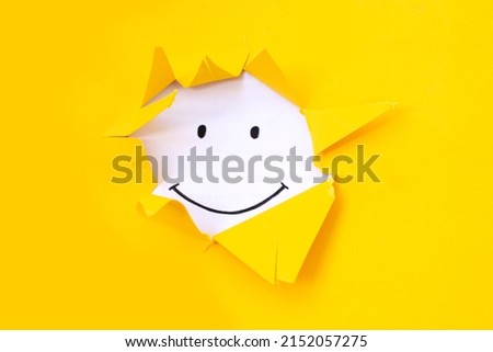 A painted smile on a white sheet on a yellow background. Positive thinking concept. having some bad feeling just keep smiling