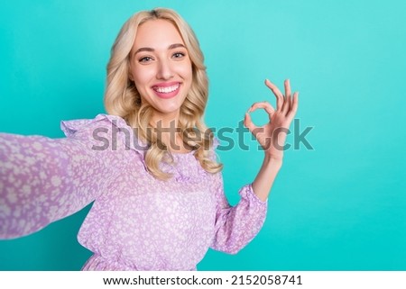 Photo of shiny sweet woman dressed purple blouse showing okey recoding self video isolated teal color background