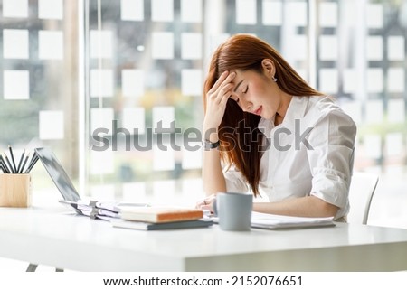 Asian women are stressed while working on laptop, Tired asian businesswoman with headache at office, feeling sick at work, copy space Royalty-Free Stock Photo #2152076651