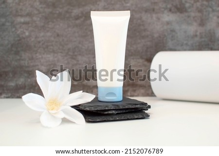 Realistic empty tubes for cosmetics. A tube of cream. Natural cosmetics. A facial and body skin care product. A white tube and a jar of cream stand on a gray background. Space for copying.