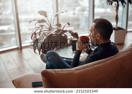 Happy adult caucasian man is sitting in a lounge zone and chilling Royalty-Free Stock Photo #2152101549