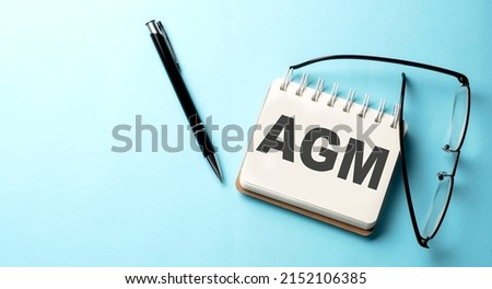 AGM text written on notepad on the blue background Royalty-Free Stock Photo #2152106385
