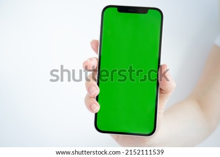 green screen on phone, smartphone mobile in hand on white background