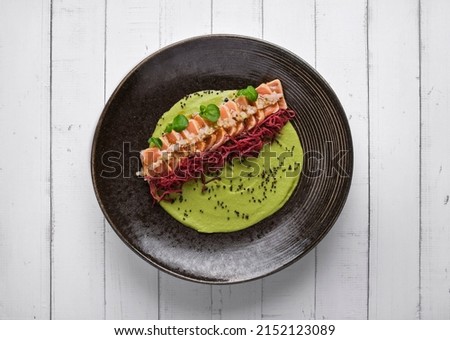 Close-up of savory Japanese salmon tataki dish topped with sesame and served with crispy strips. isolated on modern background. selective focus Royalty-Free Stock Photo #2152123089
