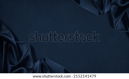 Beautiful dark blue silk satin background. Soft folds on shiny fabric. Luxury background with space for design. Web banner. Flat lay, Table top view. Christmas, Valentine's Day. Royalty-Free Stock Photo #2152141479