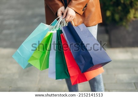 Woman holding shopping bags. Close-up portrait of colored bags