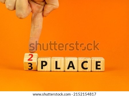 From 3 to 2 place symbol. Businessman turns wooden cubes and changes concept words 3 place to 2 place. Beautiful orange table orange background. Business and from 3 to 2 place concept. Copy space. Royalty-Free Stock Photo #2152154817