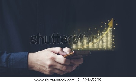  financial and investment technology concept men's hands are active Smartphone to plan stock chart analysis to invest in financial markets. The other hand has a virtual image as a candlestick chart.