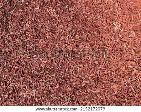 Wood chips background, pile of wood woodchips, woodworking waste. Eco playground. Decorative mulch, mulching, bark with an alement of the flower bed. Wood chips.