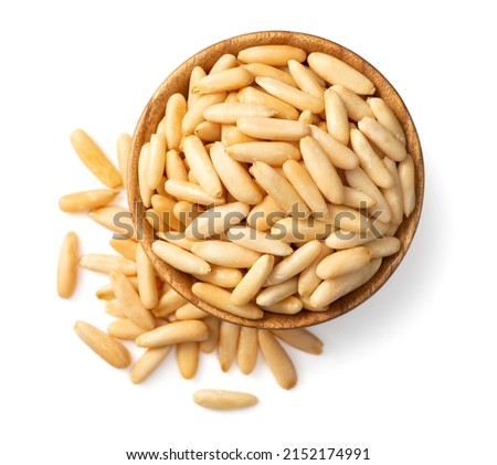 Roasted pine nuts in the wooden bowl. isolated on white background, top view. Royalty-Free Stock Photo #2152174991