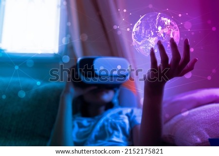 Virtual reality eyewear innovation technology concept, Kid in VR goggle gesturing watching earth on virtual screen, Elements of this earth image furnished by NASA
