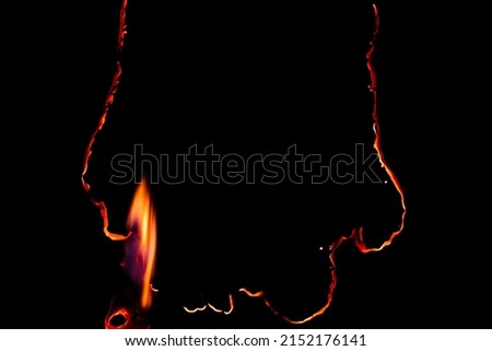 burning paper, glowing edge of paper on a black background Royalty-Free Stock Photo #2152176141